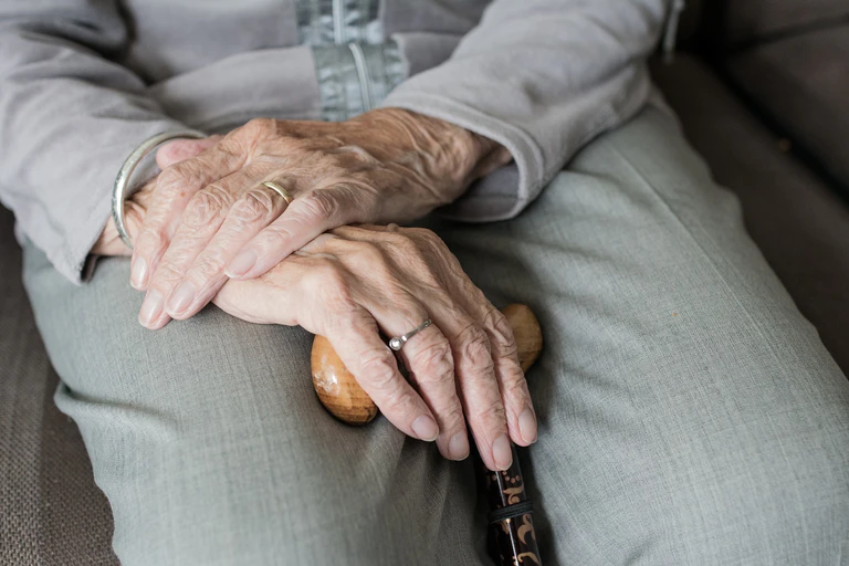 Faltige Hände einer alten Dame auf dem Schoß übereinander gelegt. — © Symbolbild