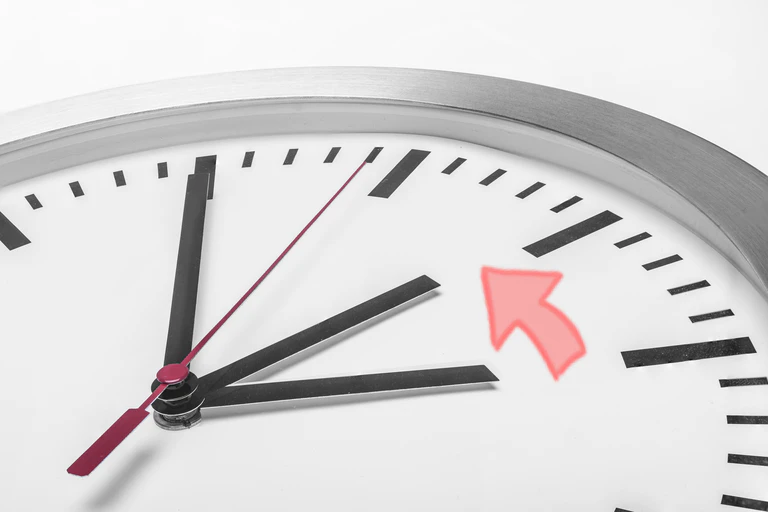 Eine Uhr mit drei Zeigern, die auf zwei und drei Uhr zeigen.